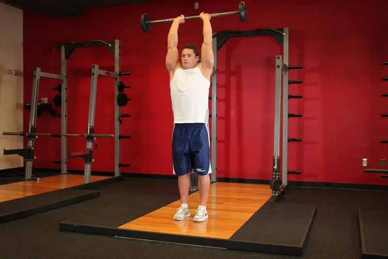 Standing Overhead Barbell Triceps Extension — finish position